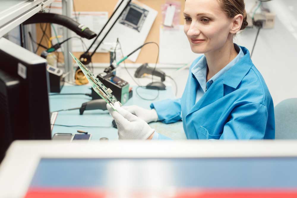 An inspector holding a PCB after optical inspection